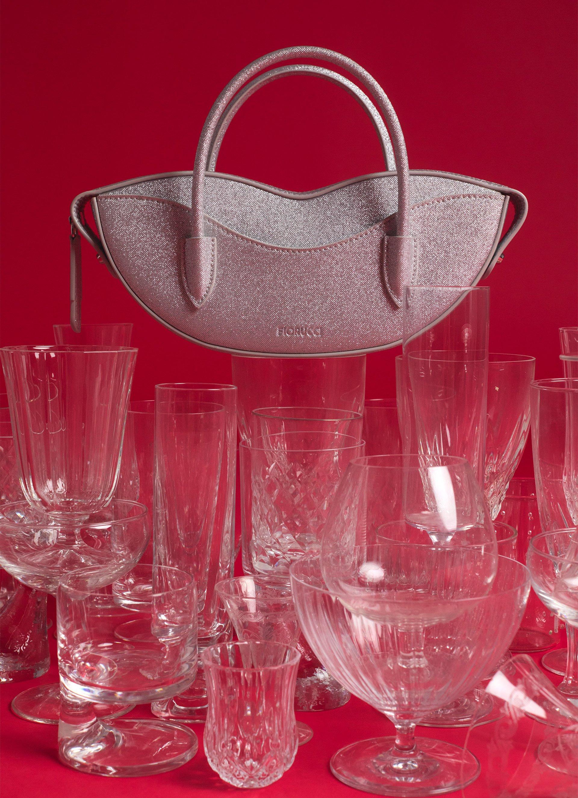 The picture features the Mini Lips Bag Glitter in Silver.